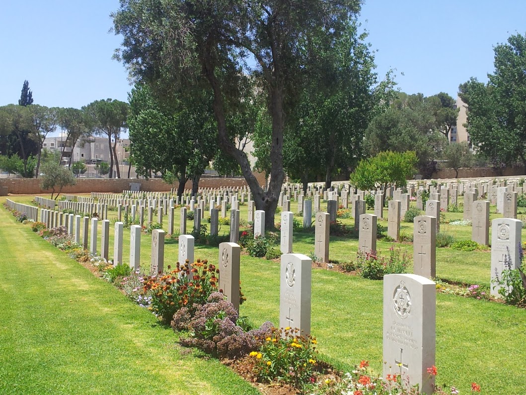 שורות מצבות אחידות בבית קברות צבאי, על מדשאה ירוקה